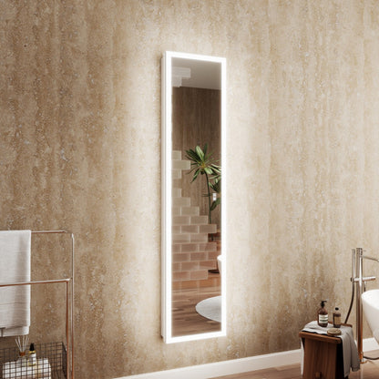 Bathroom with a tall, illuminated mirror on a textured wall.